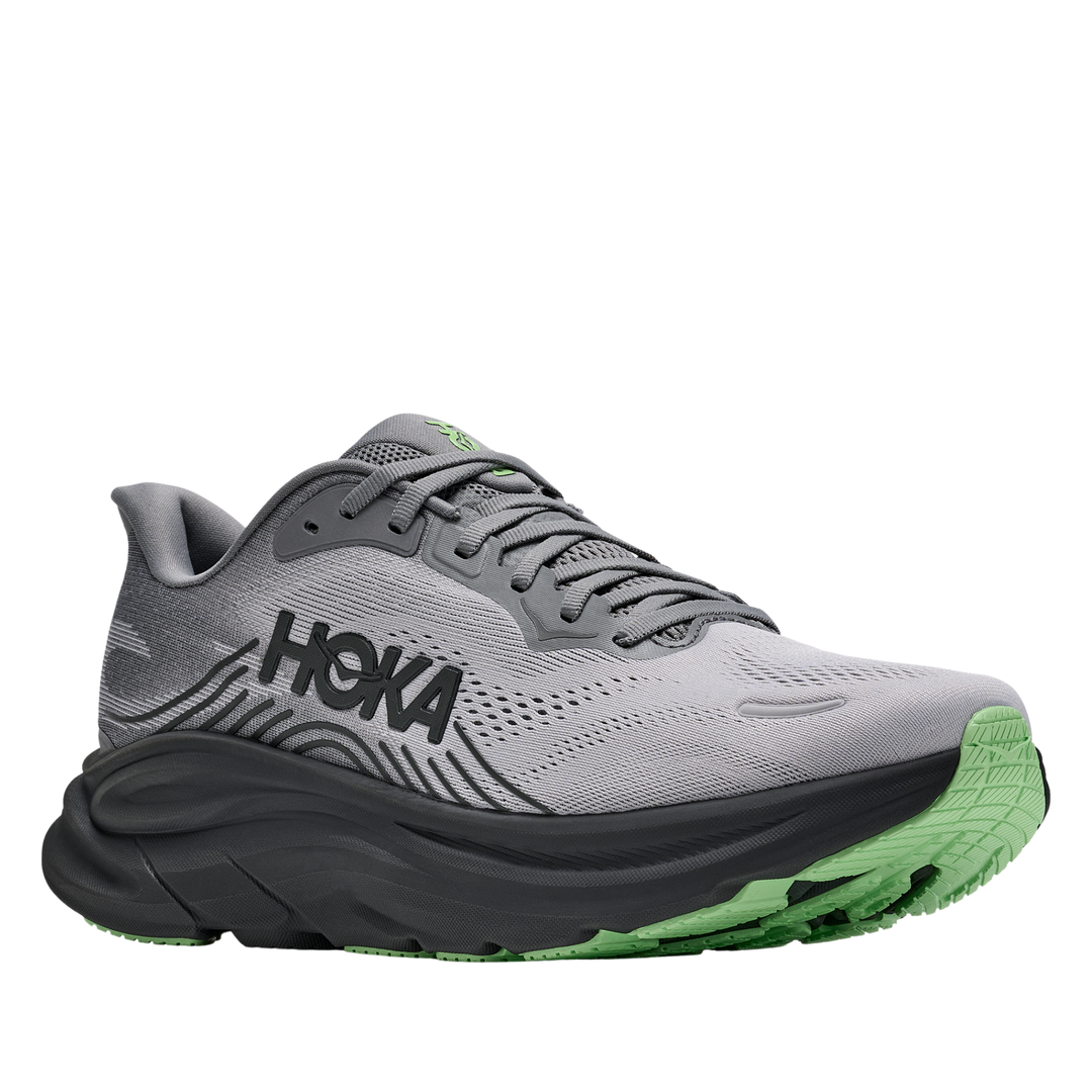 Gray running shoe with black sole and green accents on a white background