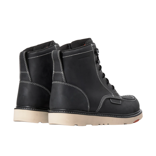 Pair of black leather boots with white soles on a light gray background