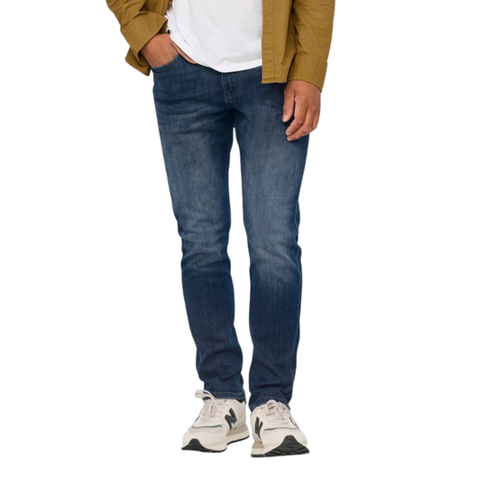 Person wearing blue jeans and a mustard jacket on a white background