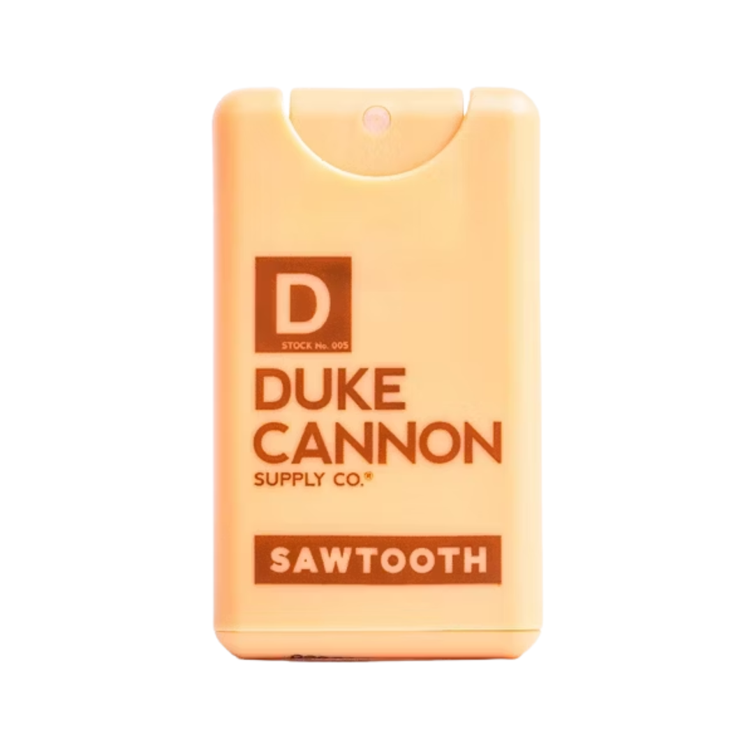Pale orange travel cologne spray bottle with a brown label and visible Sawtooth branding