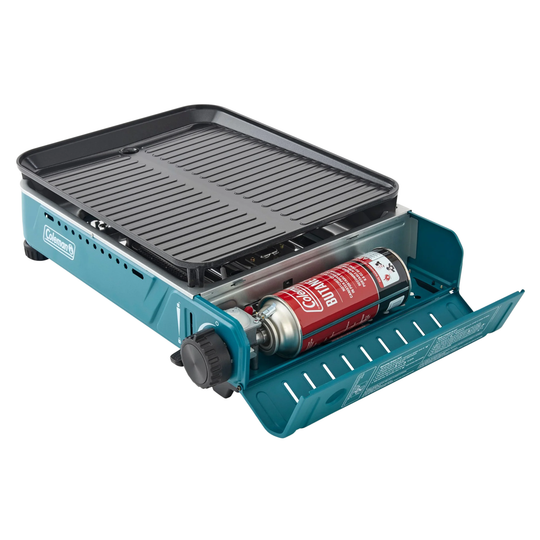 Compact tabletop gas grill with ribbed griddle plate, blue body, and visible propane canister
