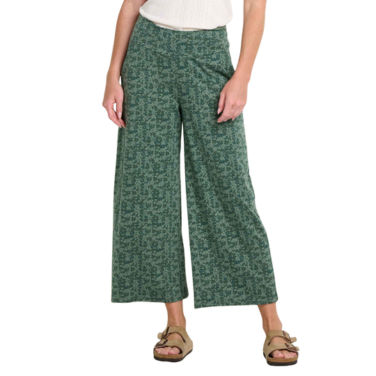 Person wearing green patterned pants on a white background