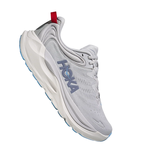 Light gray running shoe with a blue sole, side HOKA branding, and a red heel pull tab on a white background