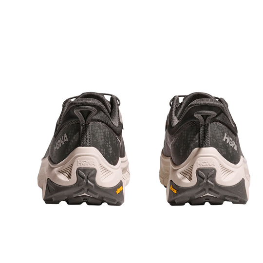 Back view of two black and gray hiking shoes with white midsoles and yellow heel accents