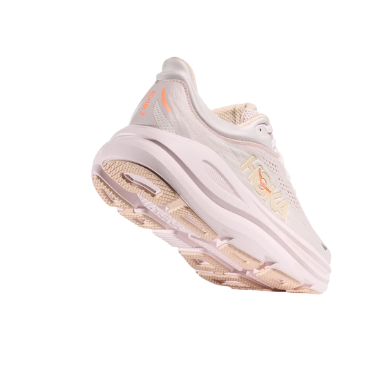 Cream-colored running shoe viewed from below, with beige tread and orange HOKA markings