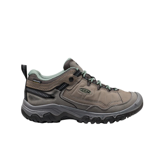 Brown hiking shoe with green accents on a white background