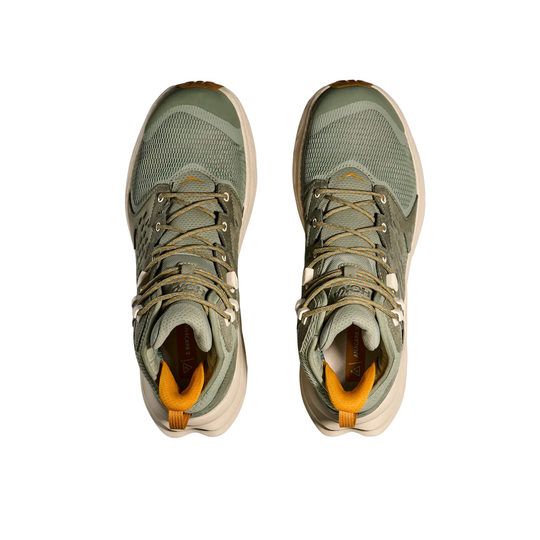 Pair of green hiking boots with orange accents on a white background