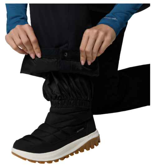 Woman wearing Columbia Women's Bugaboo III Snow Pants - Black on white background. Bottom of pant. 