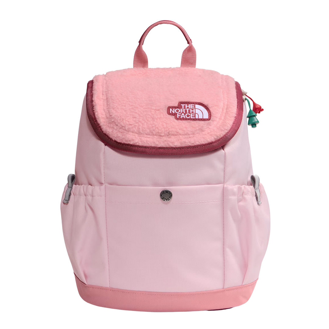 A light pink The North Face backpack with a plush fleece flap, front pocket, and silver side buckles, shown against a plain white background.