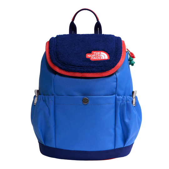A blue and navy backpack by The North Face, featuring a navy fleece flap with a red trim and a red logo patch, set against a plain white background.