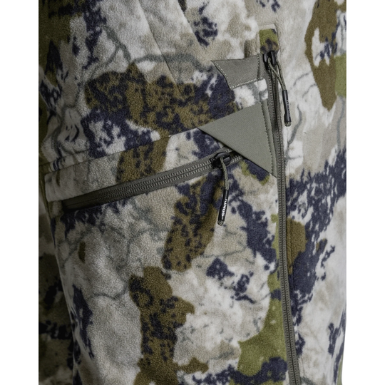 Close-up of a camouflage fleece jacket showing a zippered pocket with olive green and gray zipper details against a white background.