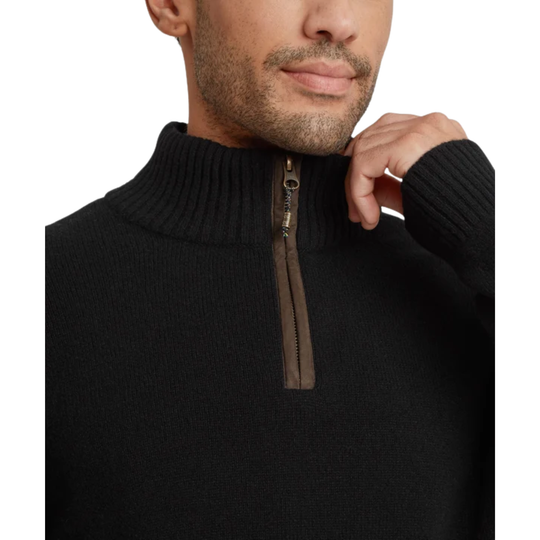 A man wearing a black ribbed mock neck quarter-zip sweater with a brown zipper pull zoomed in against a white background.