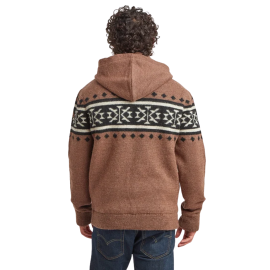A person viewed from the back wearing a brown hooded sweater with a black and white Fair Isle pattern across the shoulders and upper back, paired with blue jeans, on a plain white background.