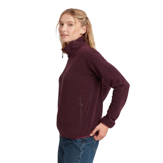 A woman modeling a dark burgundy long-sleeve fleece pullover with a mock neck and zippered pocket, paired with blue jeans against a solid white background.