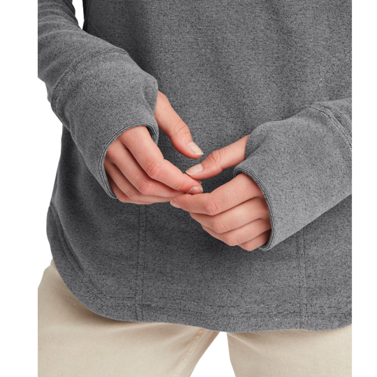 Close-up of a person wearing a heather gray long-sleeve top with thumbholes and light beige pants, shown from the chest down against a plain white background.