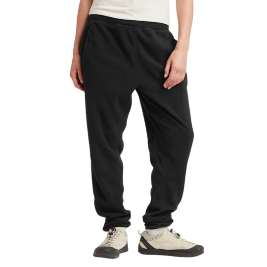 Black sweatpants shown on a model from the waist down, paired with off-white sneakers, against a plain white background.