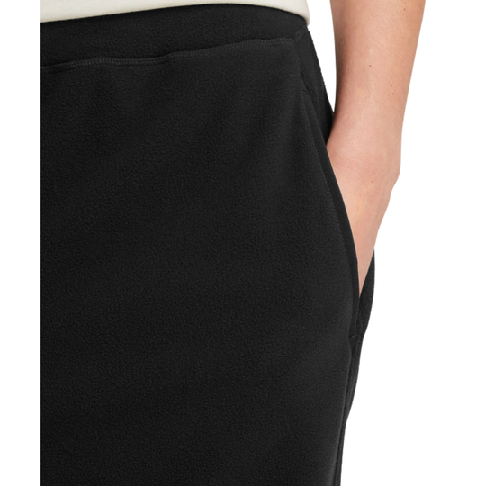 Close-up of a person wearing black fleece or sweatshirt-style bottoms, showing the side pocket and hand.