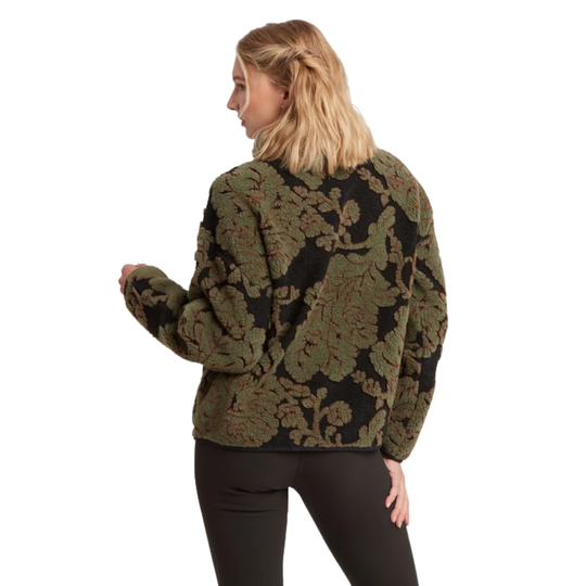 A woman shown from the back wearing a cropped, long-sleeve knit sweater with an intricate floral jacquard pattern in olive green and black, paired with black leggings, against a plain white background.