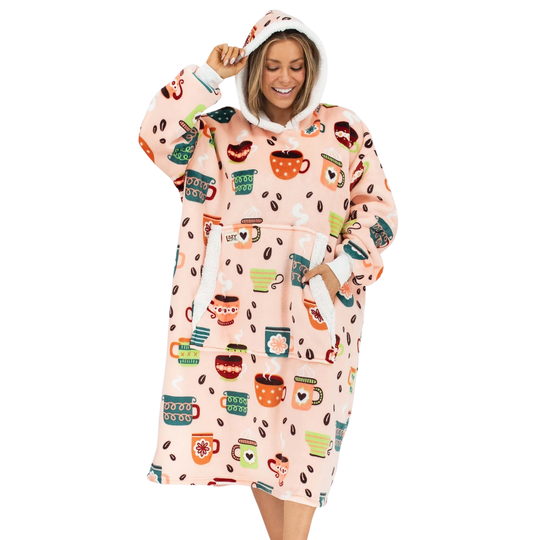 A woman wearing a light pink hooded robe with a colorful coffee-themed print, including mugs, coffee beans, and desserts, against a plain white background.