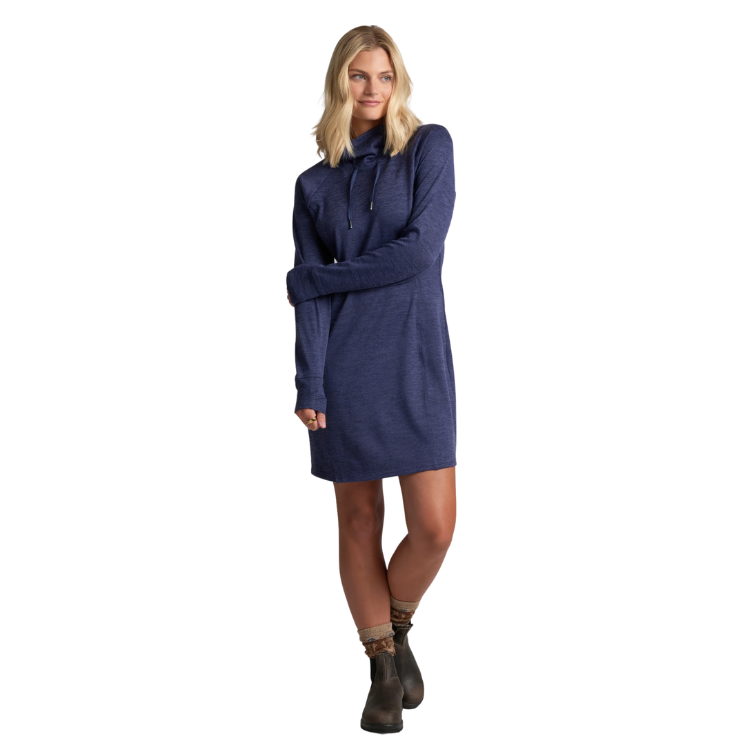 A woman modeling a navy blue long-sleeve knit dress with a mock neck and drawstring, paired with dark brown ankle boots, against a plain white background.