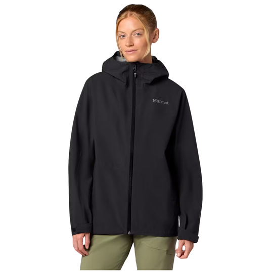 A woman wearing a black hooded zip-up jacket with a small white Marmot logo on the left chest, paired with olive green pants, against a plain white background.