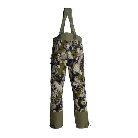 A pair of camouflage bib overalls with olive green suspenders and reinforced lower leg panels, shown against a plain white background.
