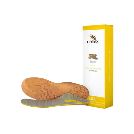 Gray and tan orthotic insoles with yellow trim beside a yellow and white Aetrex box