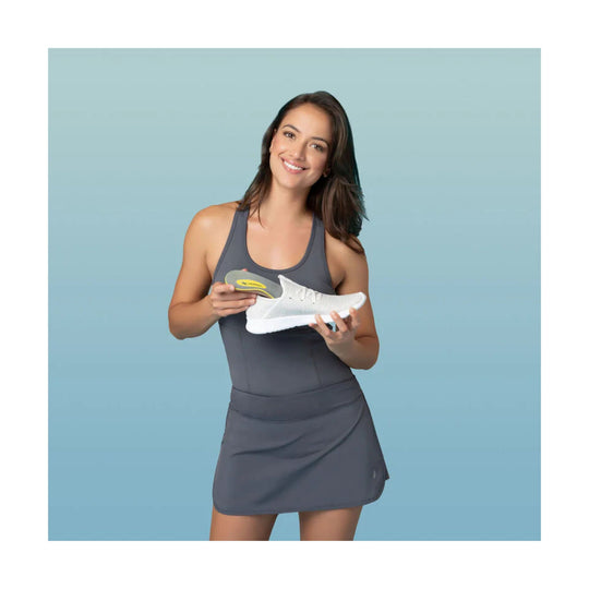 White orthotic insole with yellow and gray arch support shown in a model’s hand