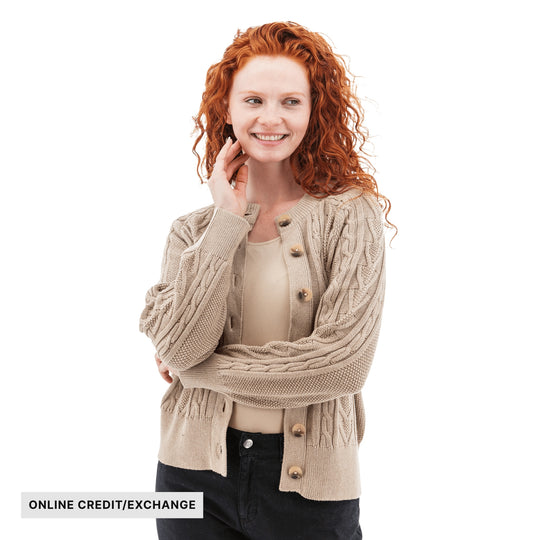 Beige cable-knit cardigan with buttons over a tank top; text reads "ONLINE CREDIT/EXCHANGE"