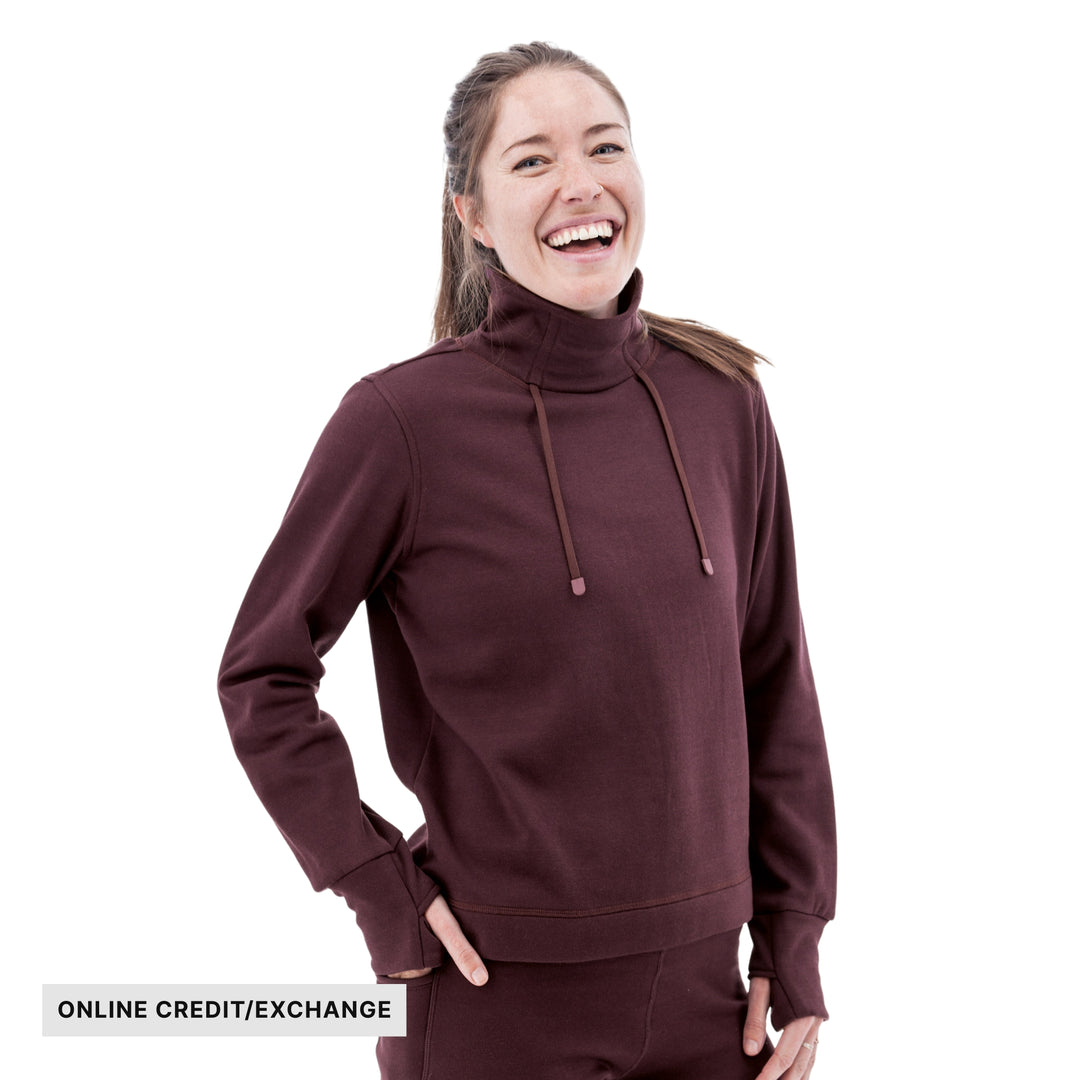 Woman wearing a burgundy fleece pullover with a high neck and drawstrings; text reads ONLINE CREDIT/EXCHANGE