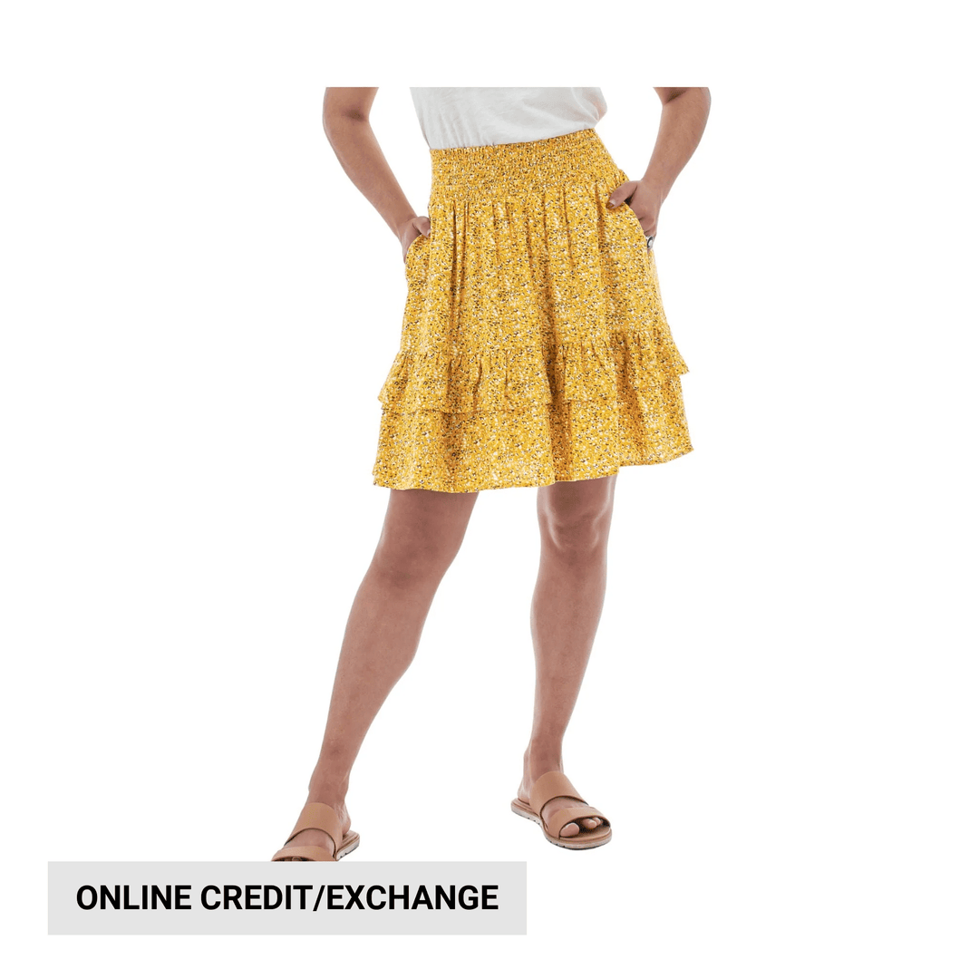 Yellow floral tiered skirt with an elastic waistband, shown on a model with hands in pockets