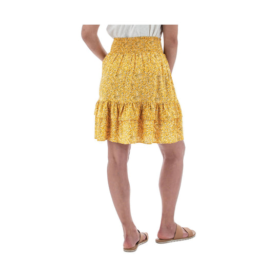 Yellow floral tiered skirt worn with a white top and tan sandals, shown from the back