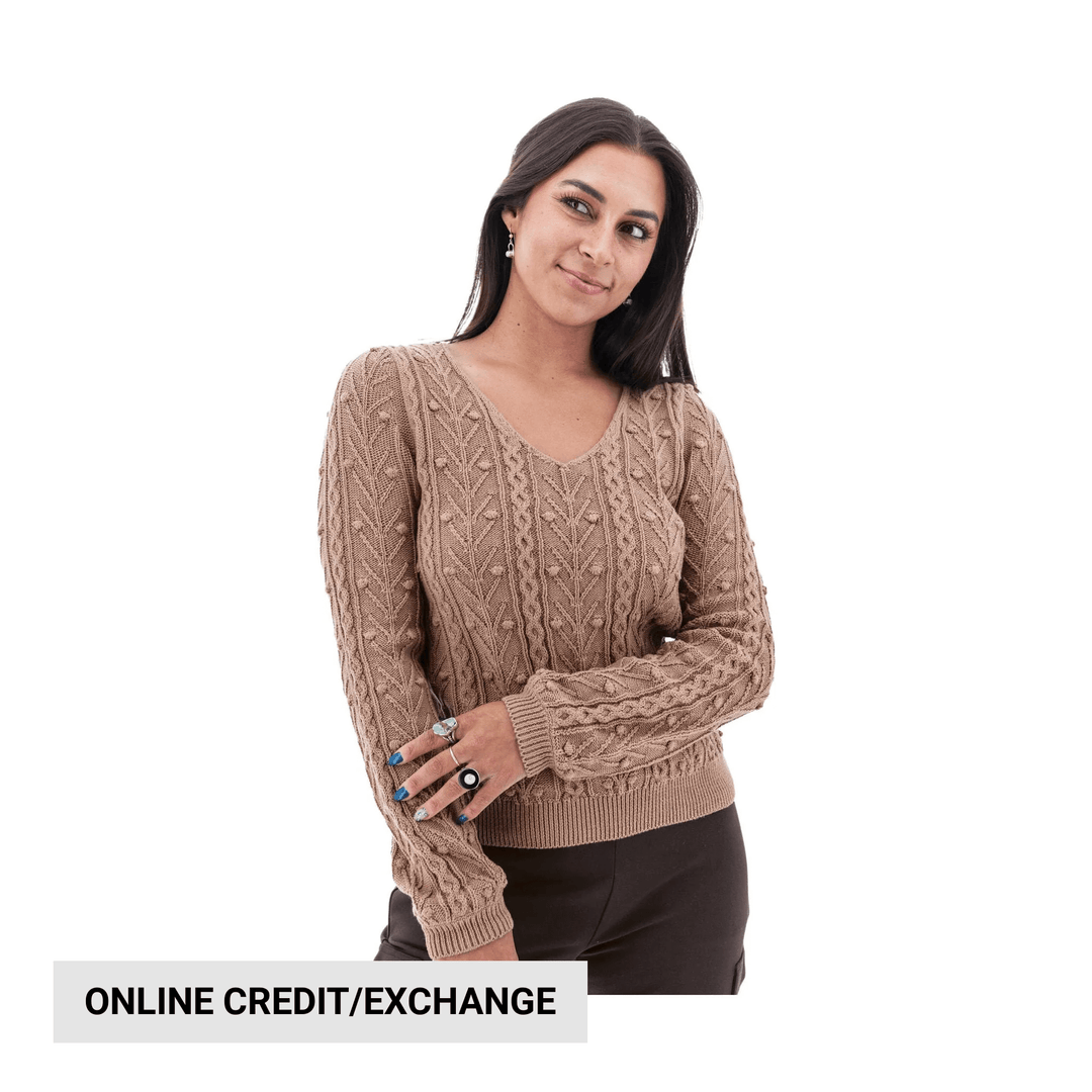 Woman wearing a beige cable-knit V-neck sweater