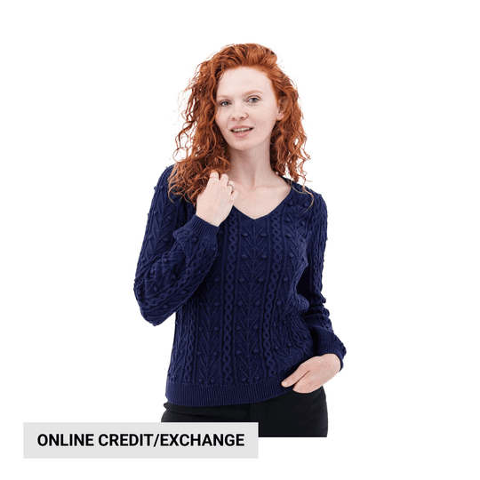 Woman wearing a navy cable-knit sweater with a V-neck and long sleeves