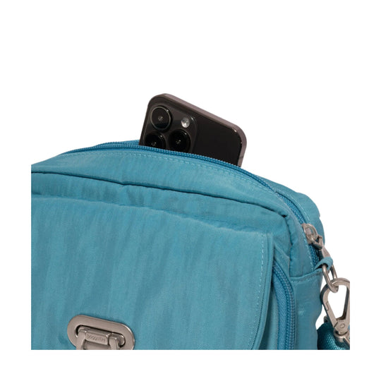 Blue crossbody bag with front zip pocket and a smartphone peeking out of the top opening