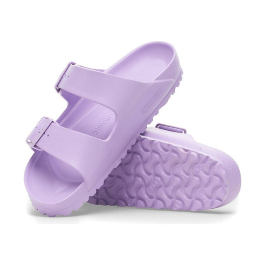 Pair of light lavender slip-on sandals with wide straps and buckled closures, shown stacked on a white background