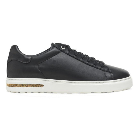 Black low-top sneaker with laces, a white platform sole, and a cork accent in the heel.