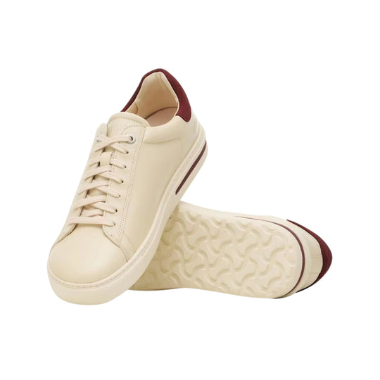 Cream low-top sneaker with burgundy heel and toe accents