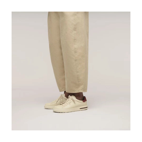 Cream low-top leather sneakers with beige pants