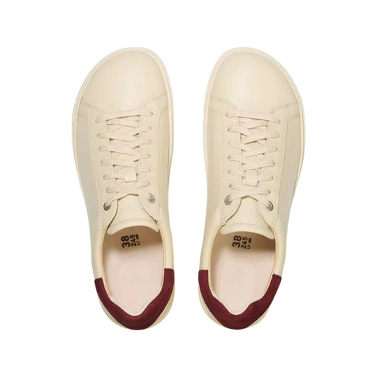 Cream low-top sneakers with burgundy heel tabs, shown pair from above