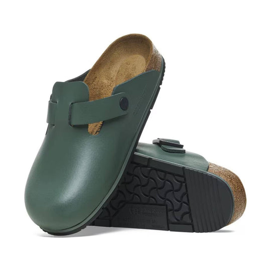Green leather clog with cork footbed and black tread sole, shown from the side