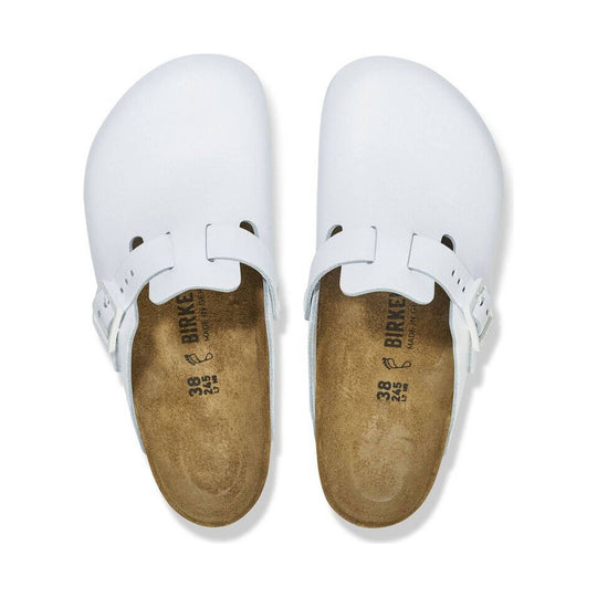 White leather clogs viewed from above with cork footbeds and adjustable side buckles