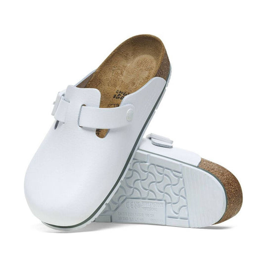 White leather clog sandals with cork footbed and adjustable strap, shown in side and top views.
