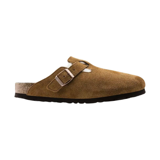 Brown suede clog with a metal buckle strap and shearling heel lining, side view