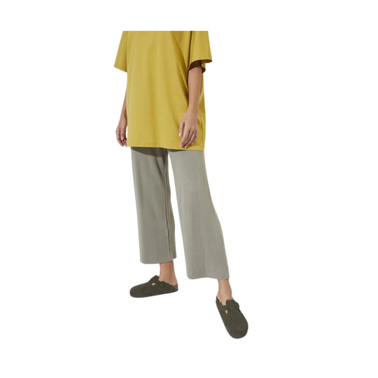 Dark olive suede clogs with an adjustable strap and closed toe, shown on a model