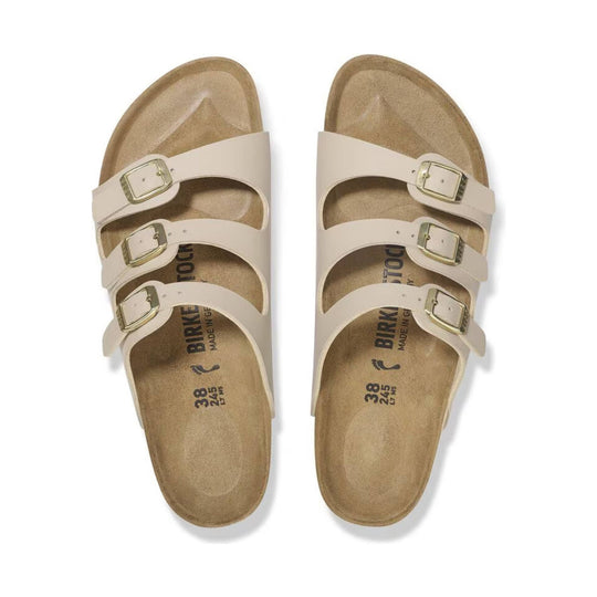 Cream three-strap sandals with gold buckles, top view
