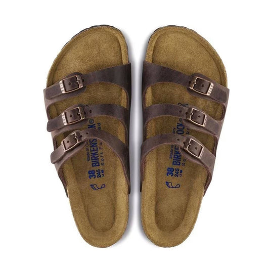 Brown three-strap cork footbed sandals with metal buckles, top view