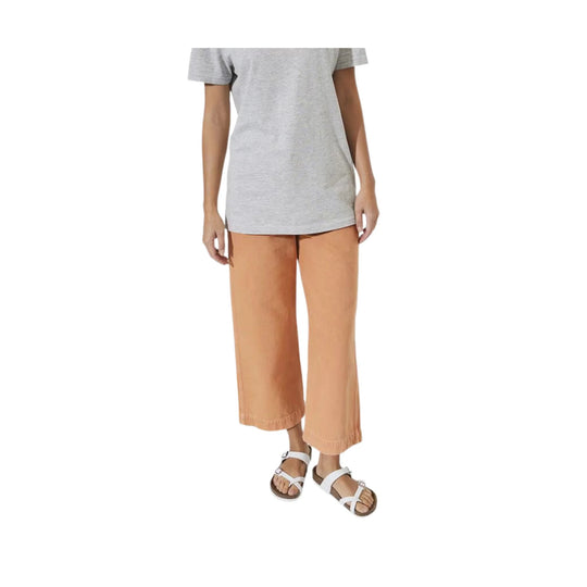 White crisscross strap sandals worn with tan wide-leg pants