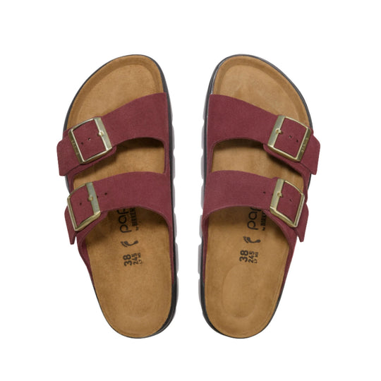 Pair of burgundy suede two-strap sandals with brass buckles and tan cork footbeds