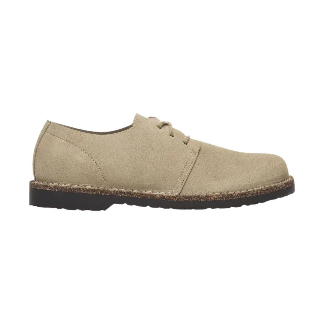Beige suede lace-up shoe with a thick black sole and speckled midsole